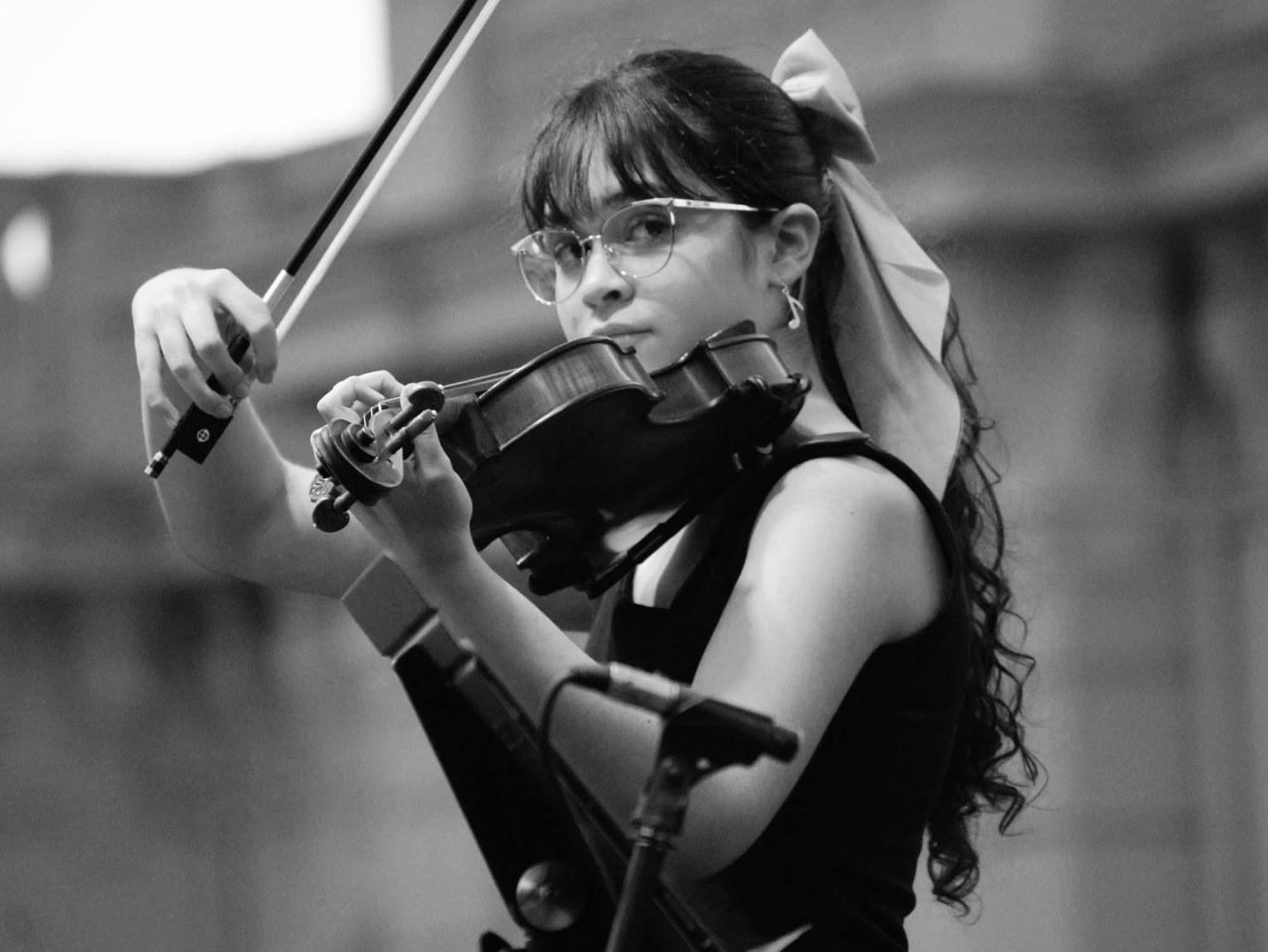 Ayla Molina-Ditter performing on violin, black and white photograph